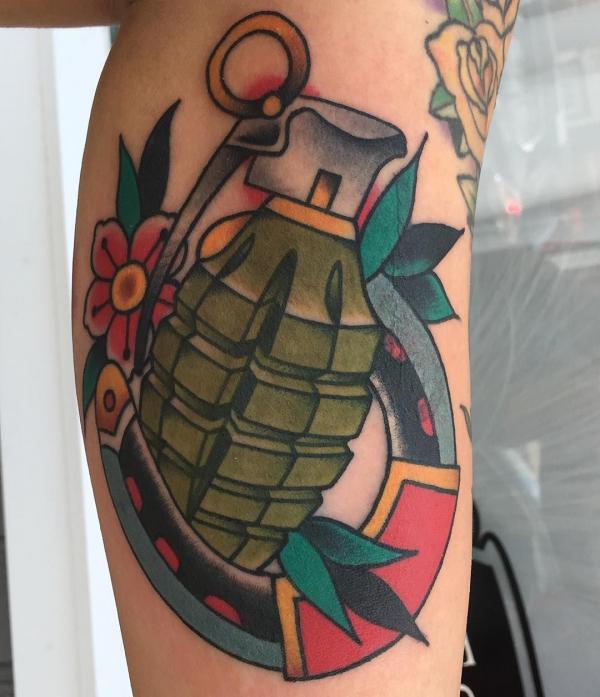 Traditional horseshoe and hand grenade tattoo on lower leg