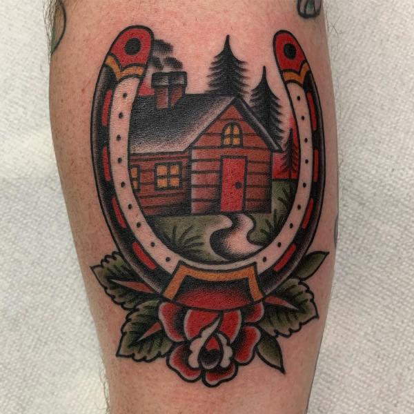 Traditional horseshoe and house with rose tattoo