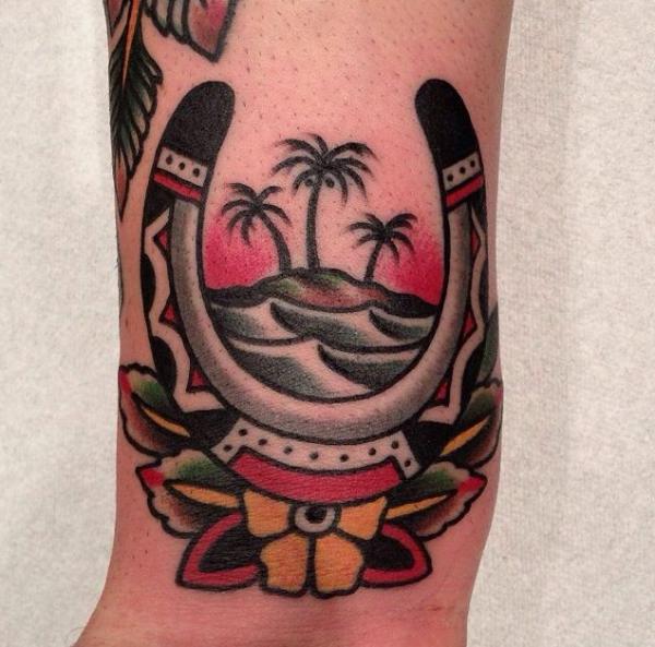 Traditional horseshoe and palm tree tattoo