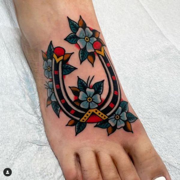Traditional horseshoe with flower foot tattoo
