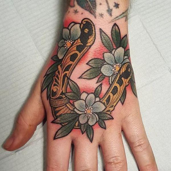 Traditional horseshoe with flower hand tattoo