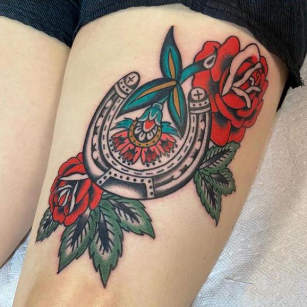 Traditional horseshoe with rose flower thigh tattoo