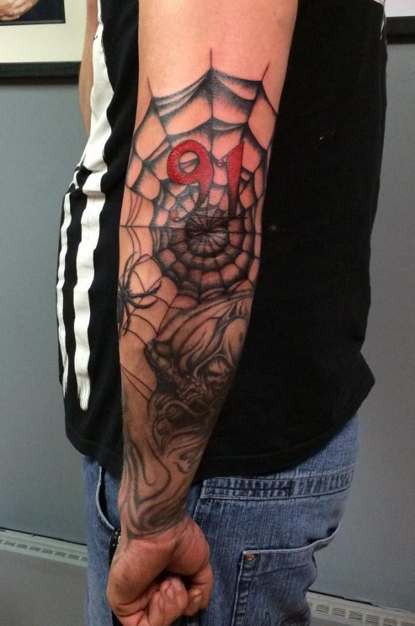 Traditional spiderweb with number 91 elbow tattoo
