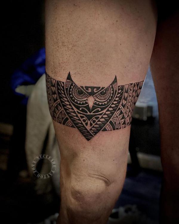 Tribal owl tattoo above knee