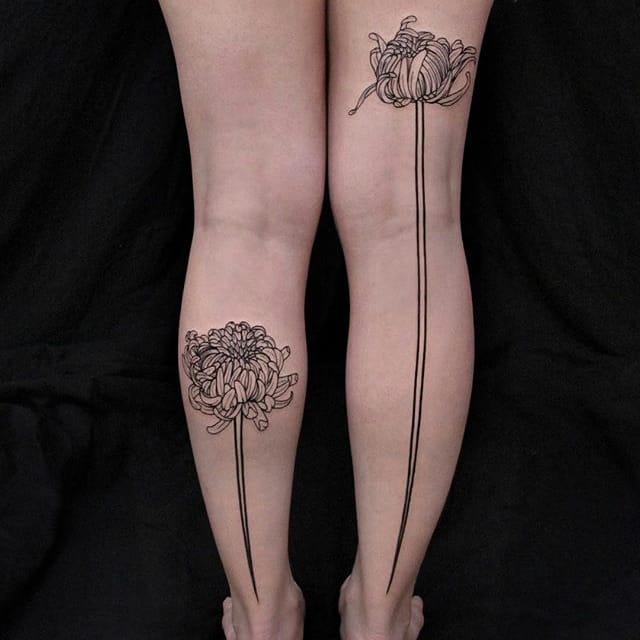 Hình xăm phác thảo hai bông hoa cúc ở mỗi chân