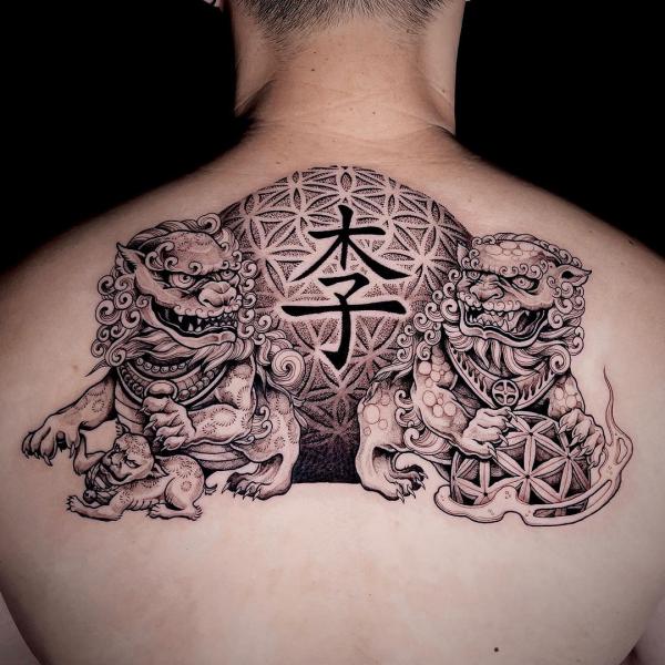 Two foo dog guarding a ball of flower of life back tattoo