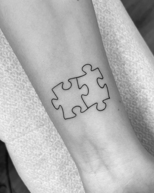 Two puzzle pieces outline tattoo