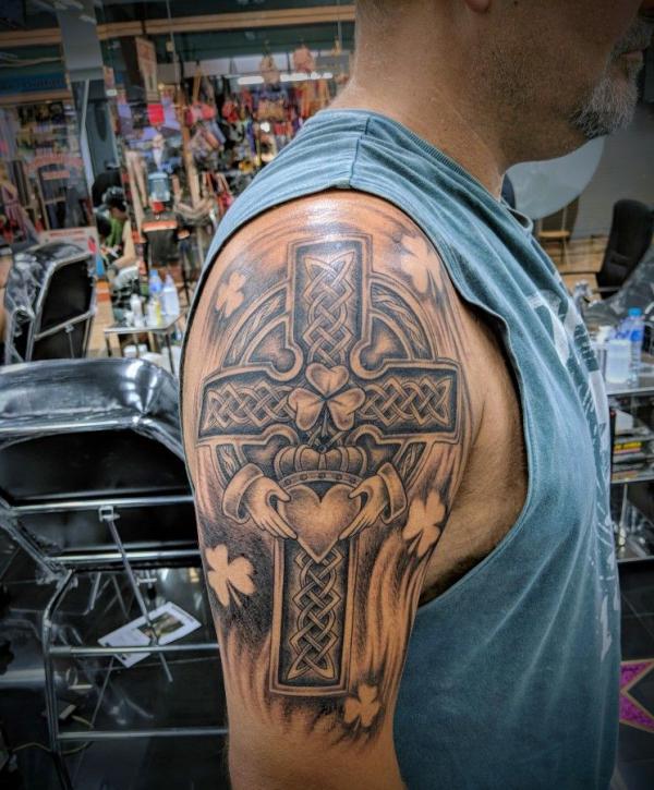 Vintage Celtic cross with claddagh and clover upper arm tattoo