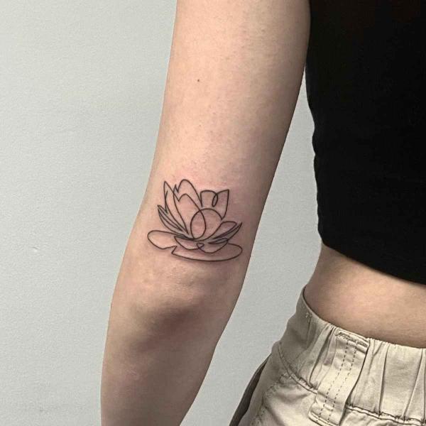 Water lily outline tattoo above elbow