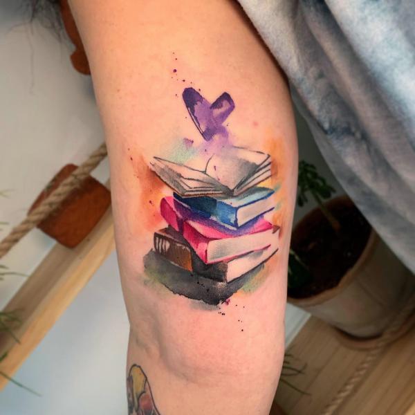 Watercolor a pile of books back of arm tattoo