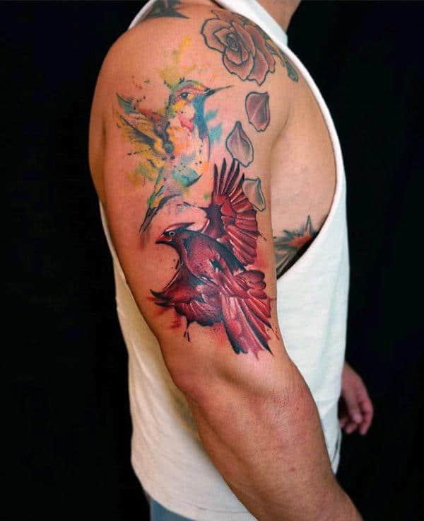 Watercolor cardinal and hummingbird tattoo on upper arm