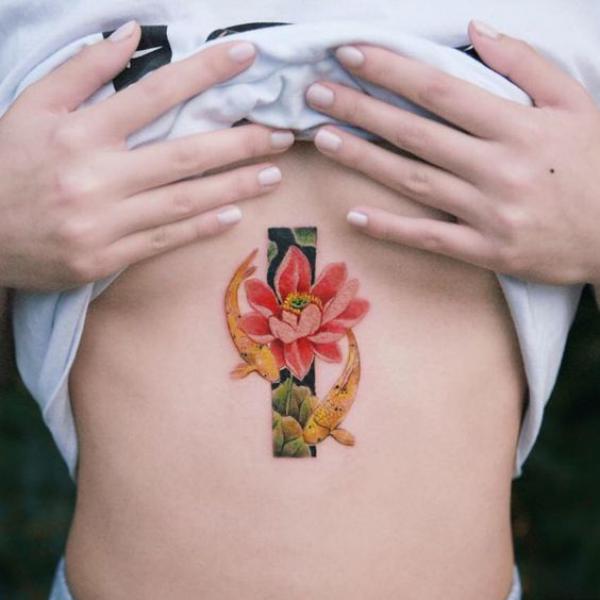 Yellow koi fish and lotus flower sternum tattoo