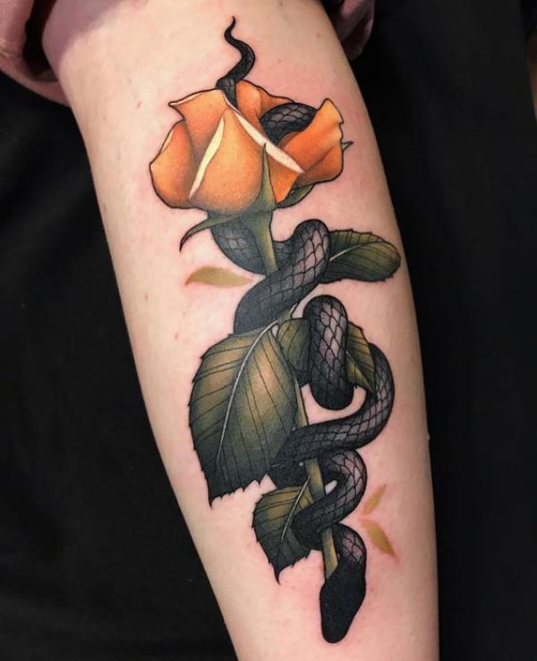 A blackwork snake interwined with a yellow rose tattoo