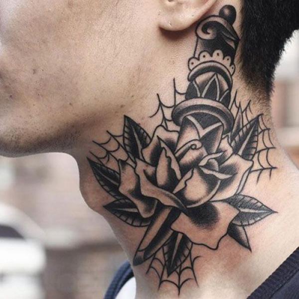 A dagger through a rose on spiderweb neck tattoo black and white traditional