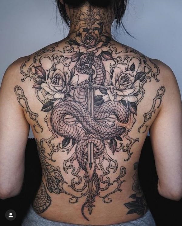 A dagger through a snake with roses and thorns back tattoo
