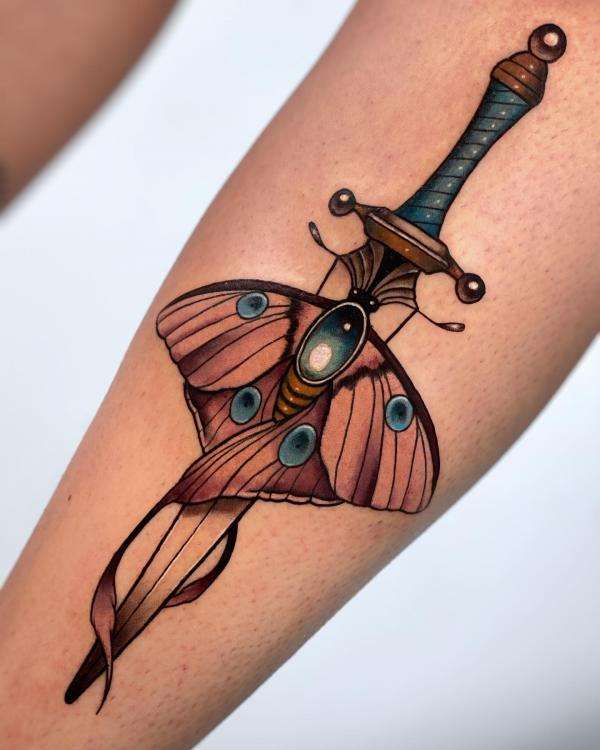 A dagger through luna moth tattoo