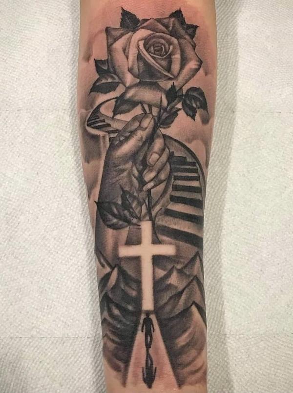 A hand holding rose and Staircase to heaven with cross tattoo