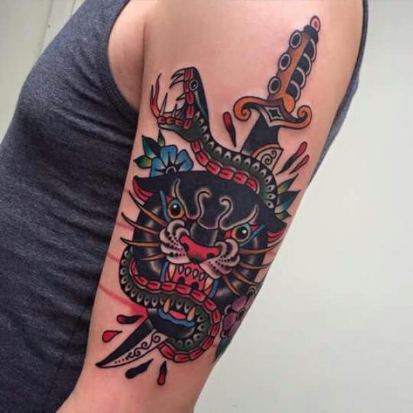 A knife through snake and panther tattoo