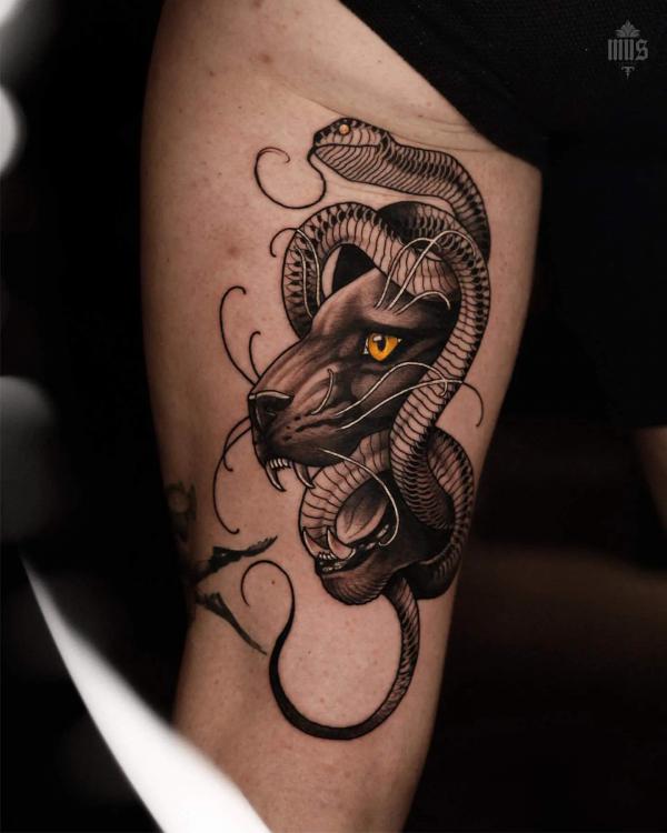 A snake interwined with panther tattoo on the back of thigh