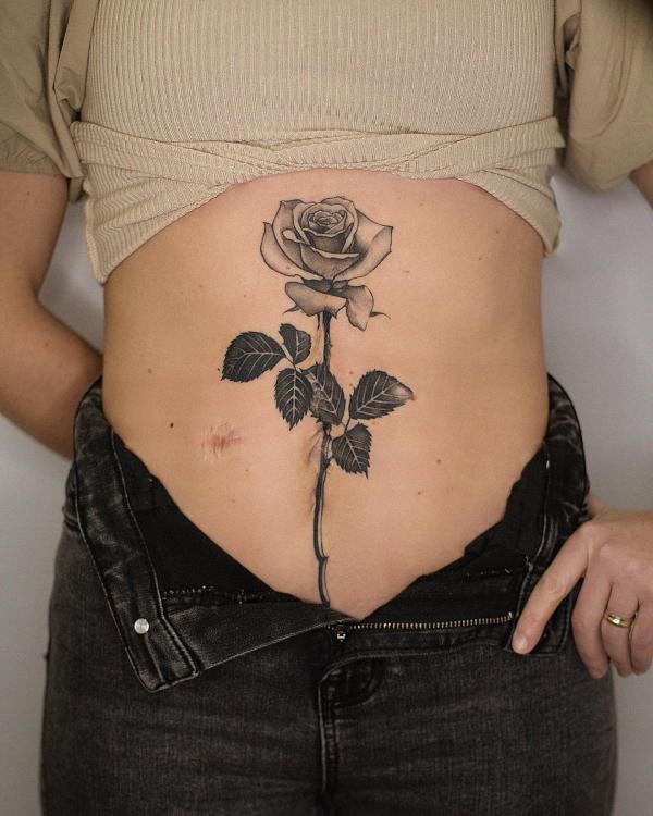 A stem of rose stomach tattoo greyscale