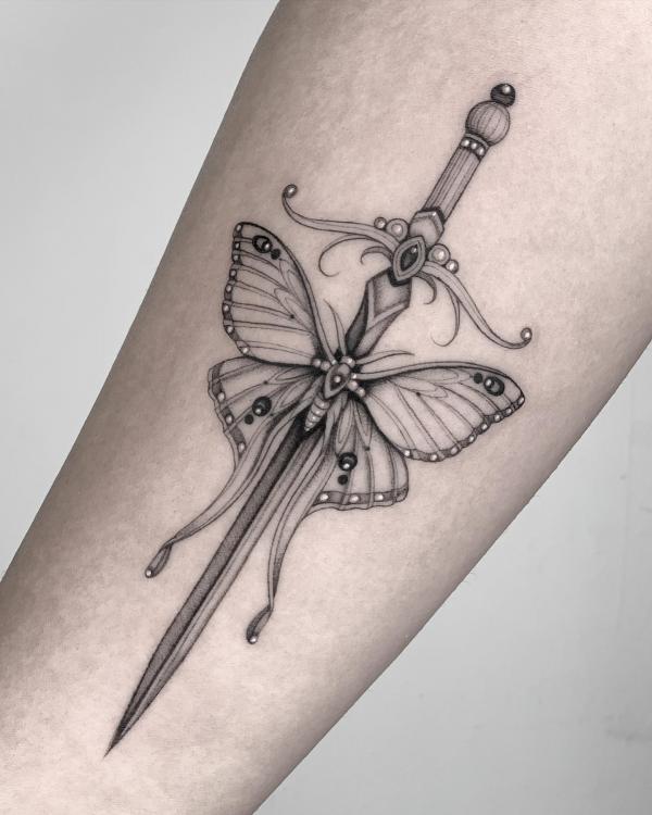 A sword through a luna moth tattoo