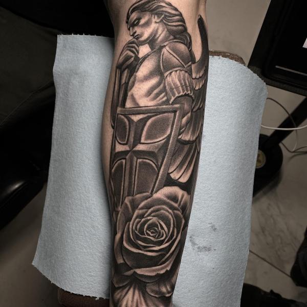Angel michael with rose tattoo on forearm