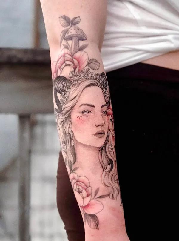 Aries girl with flowers forearm tattoo