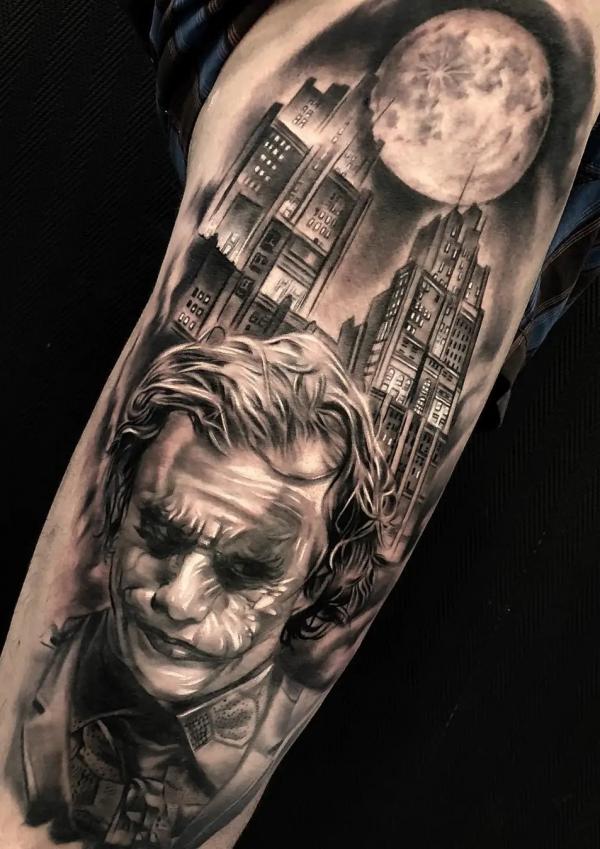Black and grey Joker and city with moon tattoo