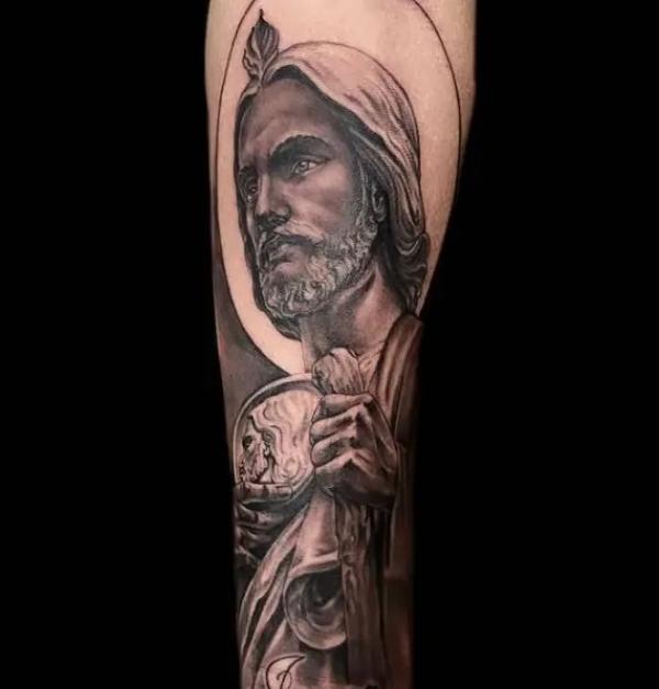 Black and grey San Judas arm tattoo