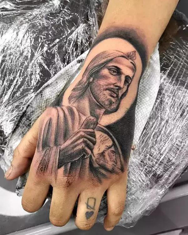 Black and grey San Judas hand tattoo