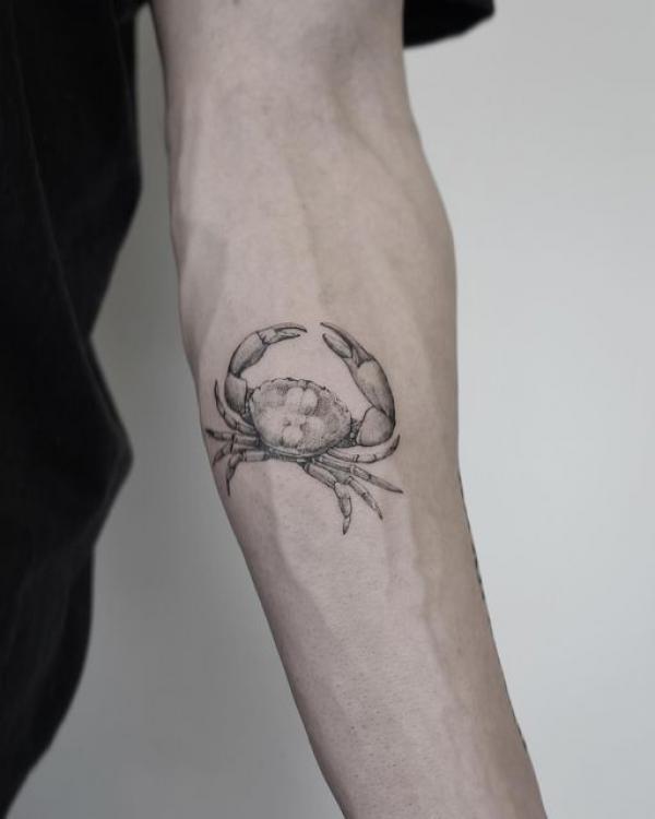 Black and grey Zodiac cancer crab tattoo on inner forearm