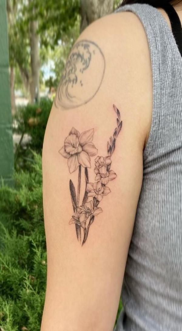 Black and grey gladiolus and daffodil tattoo