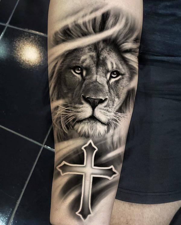 Black and grey lion king with cross forearm tattoo