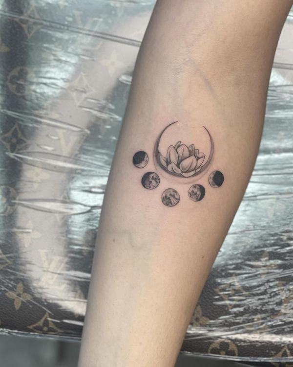 Black and grey moon phases and lotus tattoo