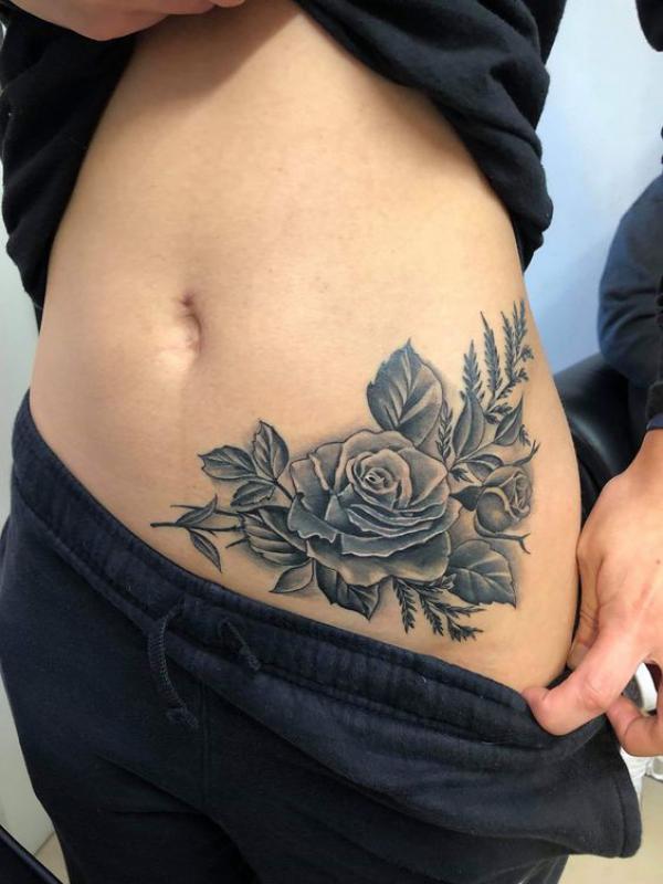 Black and grey rose side tummy tattoo