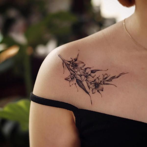 Black and white gladiolus clavicle tattoo