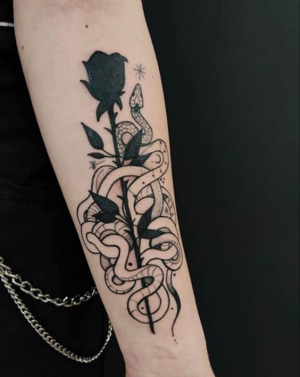 Black ink rose with snakes forearm tattoo