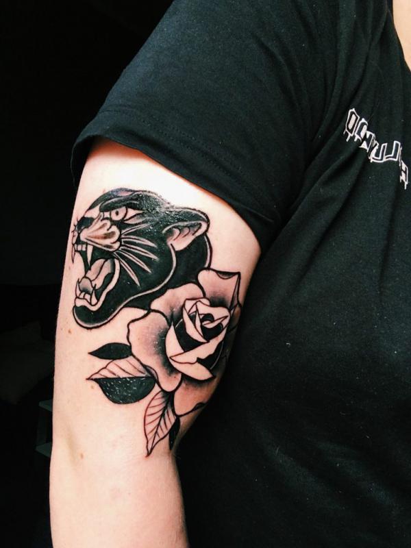 Black panther and rose upper arm tattoo