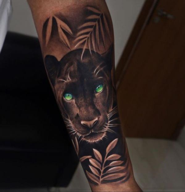 Black panther with green eyes forearm tattoo realistic