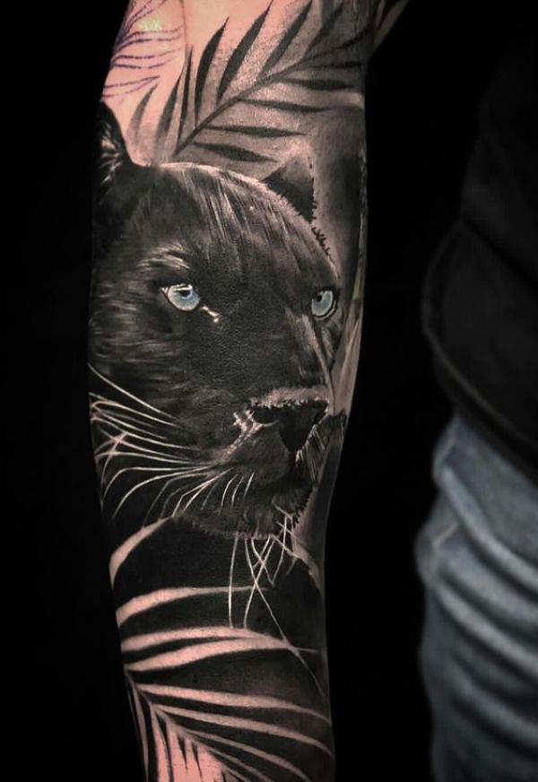 Black panther with leaves arm tattoo