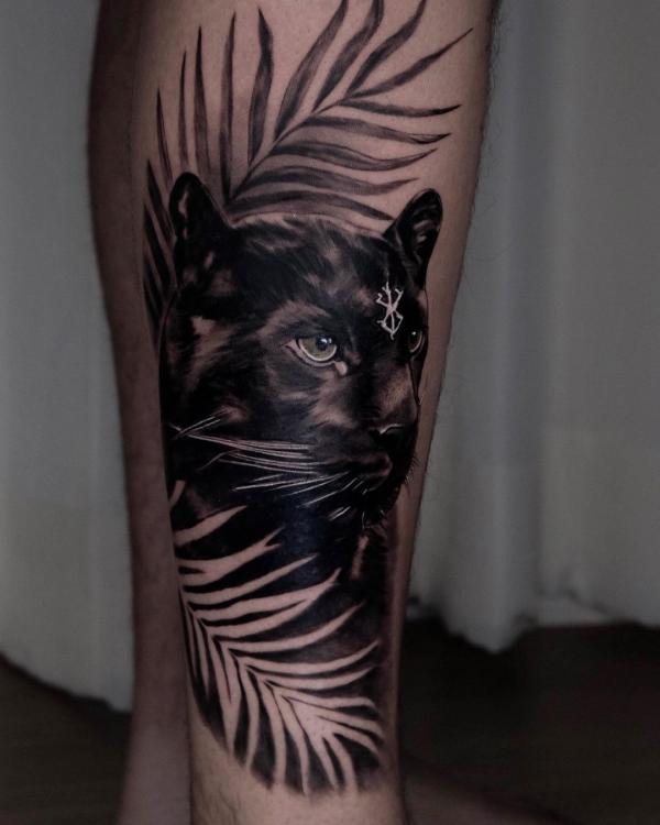 Black panther with leaves leg tattoo