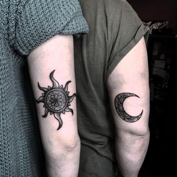 Blackwork sun and moon matching tattoo above elbow