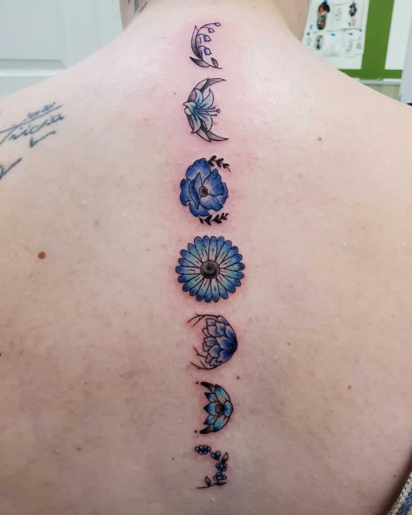 Blue floral moon cycle spine tattoo