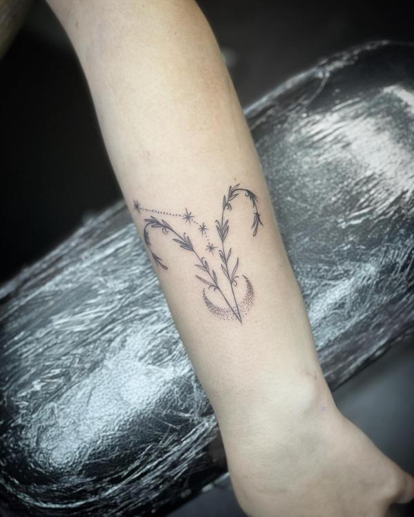 Botanical Aries glyph with crescent moon tattoo on inner forearm