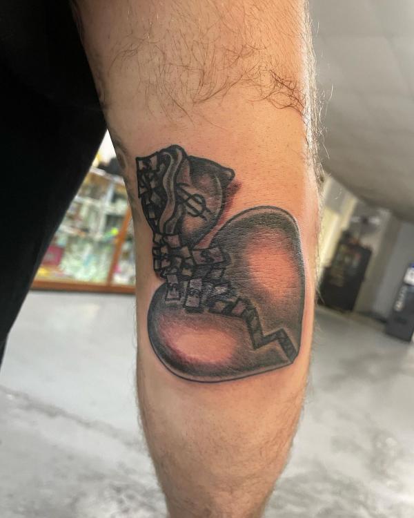 Broken heart with money bag tattoo