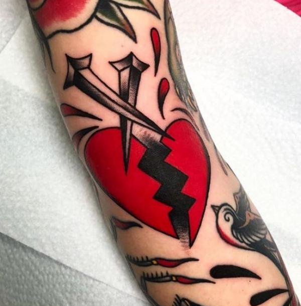 Broken heart with nails tattoo traditional