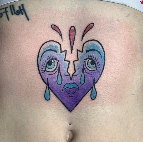 Broken heart with sad face tattoo