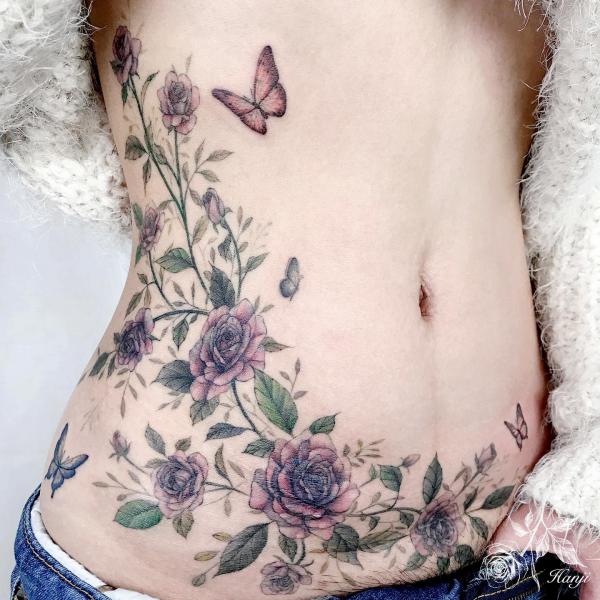Butterfly and purple rose tattoo on the side stomach