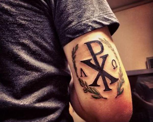 Chi Rho tattoo above elbow