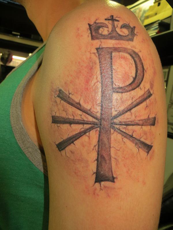 Chi Rho with crown cracked skin shoulder tattoo